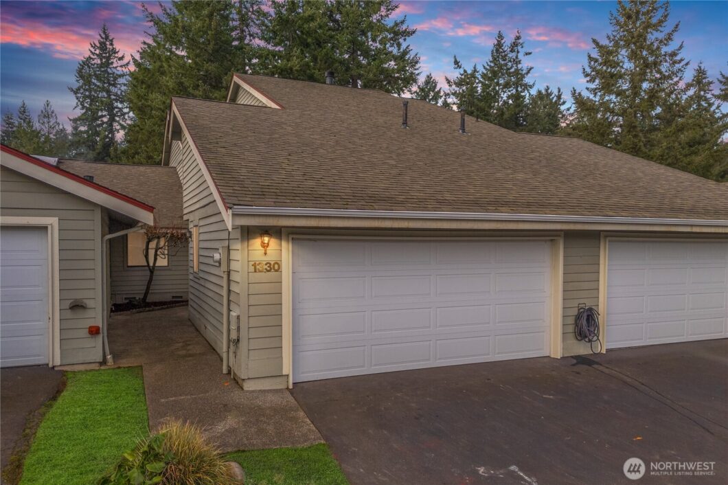 The user wants a short, descriptive sentence for the image.
- Subject: A white garage door with a roof above it.
- Details...