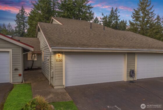 The user wants a short, descriptive sentence for the image.
- Subject: A white garage door with a roof above it.
- Details...