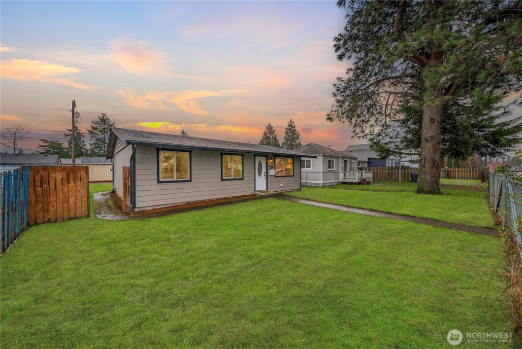 The user wants a short, descriptive sentence for the image.
- **Subject:** A single-story house (ranch style) with green s...