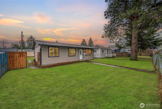 The user wants a short, descriptive sentence for the image.
- **Subject:** A single-story house (ranch style) with green s...